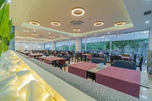a restaurant with purple tables and chairs and windows at Q Ella Beach Hotel in Side