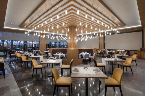 a restaurant with tables and chairs and a projection screen at Trendy Lara in Lara