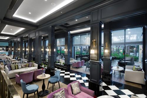 a hotel lobby with tables and chairs and windows at Trendy Lara in Lara