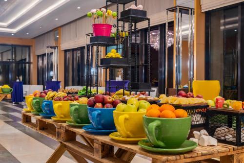 a buffet line with bowls of fruit on a table at Trendy Lara in Lara