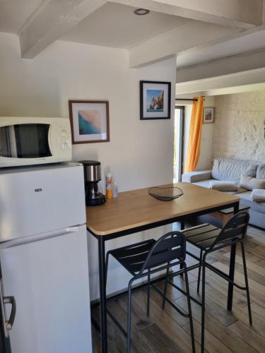 Il comprend une cuisine équipée d'un réfrigérateur, d'une table et de chaises. dans l'établissement Penty près de la mer, à Combrit