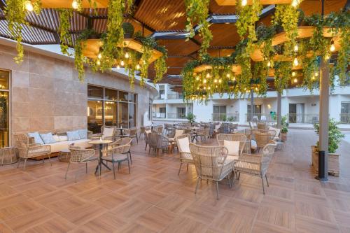 a restaurant with tables and chairs in a building at Kirman Belazur Resort & Spa in Belek