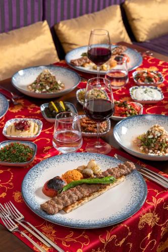a table with plates of food and glasses of wine at Kirman Belazur Resort & Spa in Belek