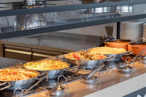 a kitchen with four pans of food on a counter at Kirman Belazur Resort & Spa in Belek