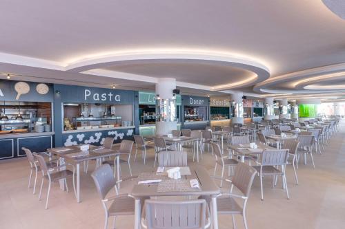 a dining room with tables and chairs in a restaurant at Kirman Belazur Resort & Spa in Belek