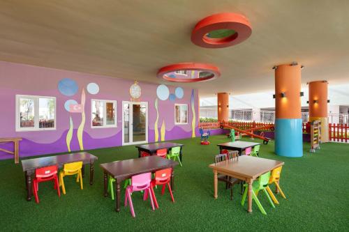 a colorful classroom with tables and chairs in a room at Kirman Belazur Resort & Spa in Belek