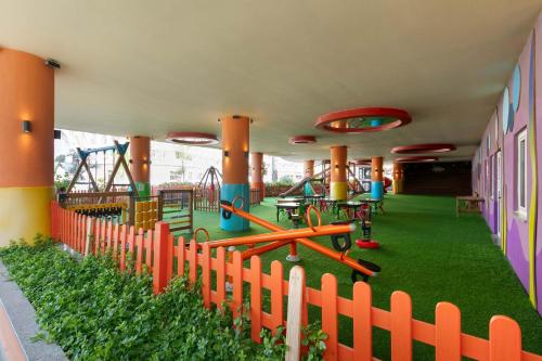 a playground with play equipment and a fence at Kirman Belazur Resort & Spa in Belek