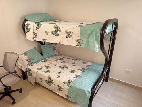 ビジェータにあるLindo y acogedor apartamentoの二段ベッド1組と椅子1脚が備わります。