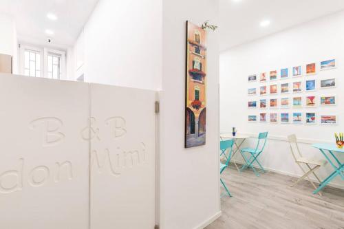 a room with a white wall with a table and chairs at b&b don Mimì in Naples