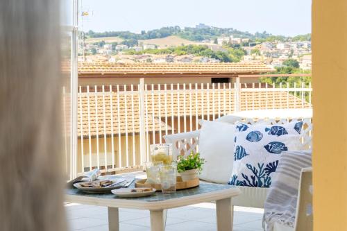 a table in a room with a view of a balcony at Italian Experience-Sopraloreto Apartment in Loreto