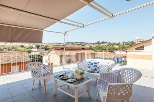 a patio with chairs and a table on a balcony at Italian Experience-Sopraloreto Apartment in Loreto
