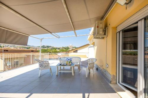 a patio with a table and chairs on a balcony at Italian Experience-Sopraloreto Apartment in Loreto