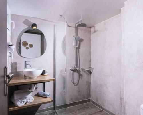 a bathroom with a shower with a sink and a mirror at Elea Terra Hotel in Matala