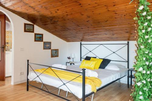 a bed in a room with a wooden ceiling at Italian Experience-Sopraloreto Apartment in Loreto