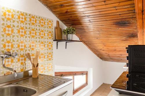 a kitchen with a sink and a wooden ceiling at Italian Experience-Sopraloreto Apartment in Loreto