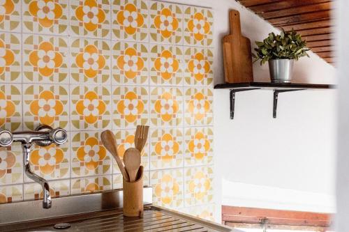 a kitchen with yellow and white tiles on the wall at Italian Experience-Sopraloreto Apartment in Loreto