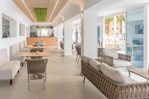 a restaurant with tables and chairs and windows at Hotel Amic Horizonte in Palma de Mallorca