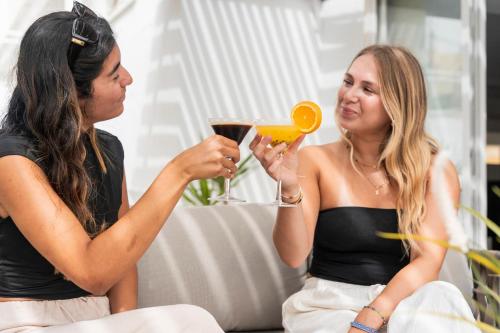 two women sitting on a couch looking at a mirror at Hotel Amic Horizonte in Palma de Mallorca