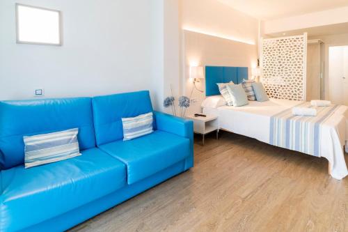 a living room with a blue couch and a bed at Hotel Amic Horizonte in Palma de Mallorca