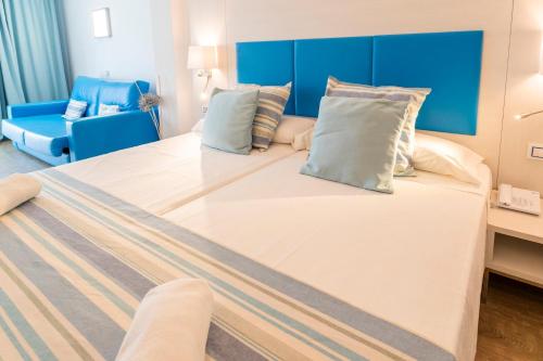 a large bed with pillows on it in a room at Hotel Amic Horizonte in Palma de Mallorca