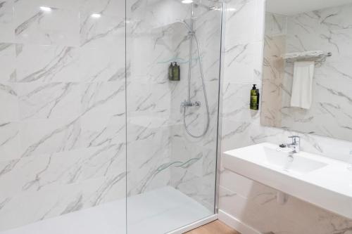 a white bathroom with a shower and a sink at Hotel Amic Horizonte in Palma de Mallorca