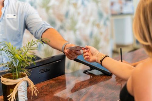 a man and a woman shaking hands at a table at Hotel Amic Horizonte in Palma de Mallorca