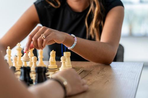 a woman sitting at a table playing chess at Hotel Amic Horizonte in Palma de Mallorca