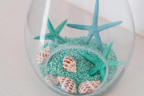 a glass vase filled with sand and starfish at Hotel Amic Horizonte in Palma de Mallorca