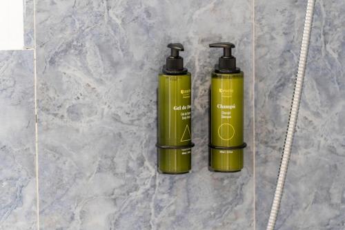 two green bottles sitting on top of a counter at Hotel Amic Horizonte in Palma de Mallorca