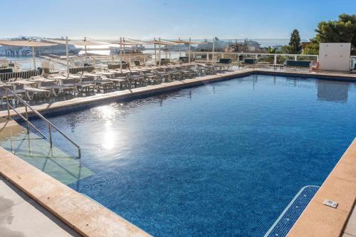 a large swimming pool with tables and chairs at Hotel Amic Horizonte in Palma de Mallorca