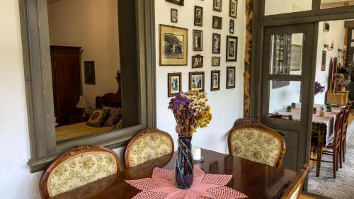 a dining room with a table and chairs and a mirror at Locul cu Amintiri in Albac