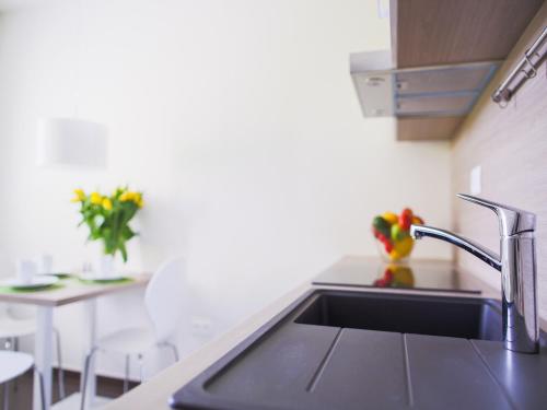 a kitchen with a sink and a table with flowers at Villa Irene in Trenčianske Teplice