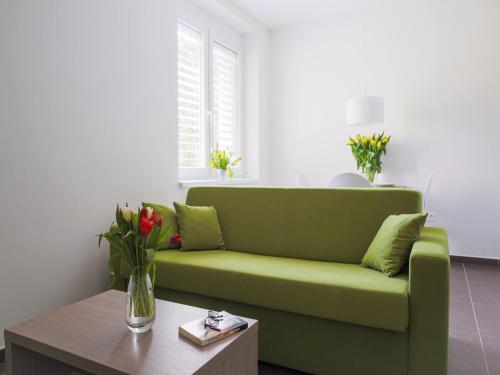 a green couch in a living room with a coffee table at Villa Irene in Trenčianske Teplice