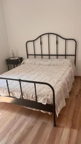 a bed with a black metal frame in a bedroom at Casinha do mar in Buarcos