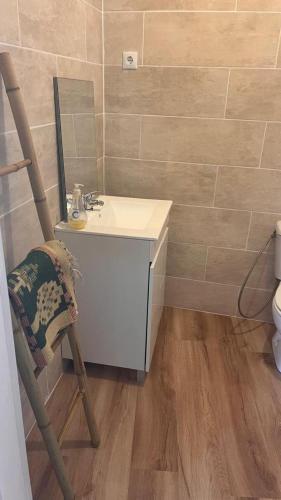 a bathroom with a sink and a mirror and a chair at Casinha do mar in Buarcos