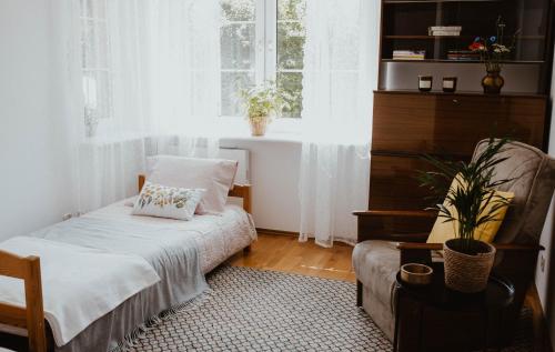ein Schlafzimmer mit einem Bett, einem Stuhl und einem Fenster in der Unterkunft Sielanka Dom nad Morzem in Sławoszyno