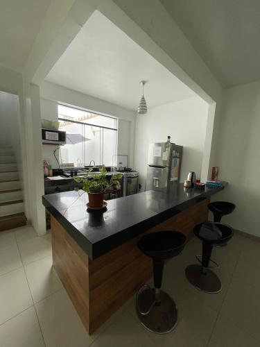a kitchen with a large counter with stools in it at Killamoon House Paracas in Paracas
