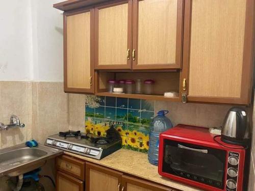 a kitchen with a counter top with a red microwave at شاليه مكيف بقريه الأندلسيه in Marsa Matruh