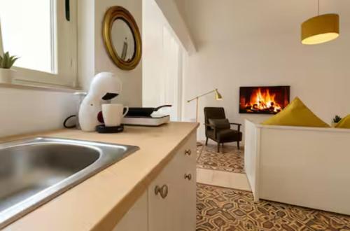 a kitchen with a sink and a living room with a fireplace at Stylish accommodation in Sliema Exiles in Sliema