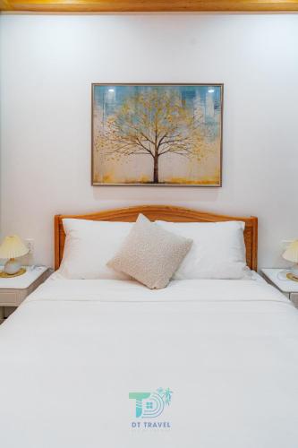 a bedroom with a bed with a painting on the wall at DT Retreat - Biệt thự nguyên căn - 3 Phòng ngủ - Novaworld Phan Thiết in Phan Thiet
