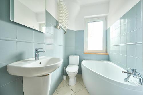 a bathroom with a sink and a tub and a toilet at GM Jagiellończyk in Olsztyn