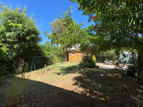 un jardin avec une maison en bois en arrière-plan dans l'établissement Charming quiet pool villa, à Toulon