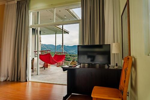 a living room with a television and a large window at Casa Ejecutiva Boquete in Boquete