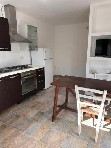 a kitchen with a wooden table and chairs in it at Tentadore in La Caletta