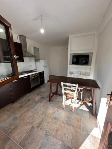 a kitchen with a wooden table and a wooden chair at Tentadore in La Caletta