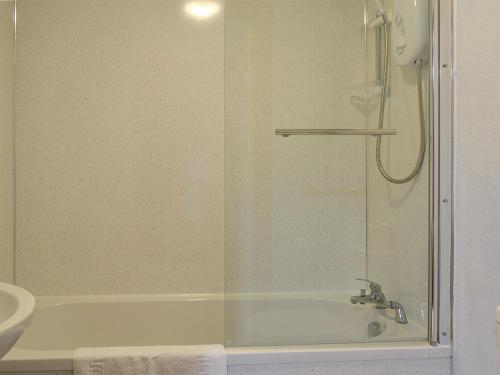 a bathroom with a shower and a tub and a sink at Hoot House in Abergynolwyn