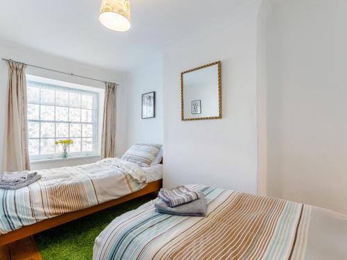 two beds in a room with a window at The Square in Hartland