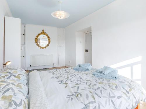 a white bedroom with a large bed and a mirror at The Square in Hartland