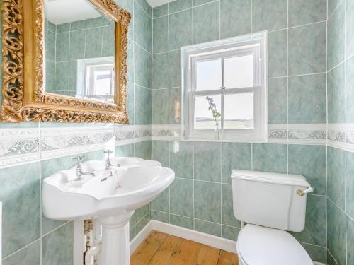 a bathroom with a sink and a toilet and a mirror at The Square in Hartland