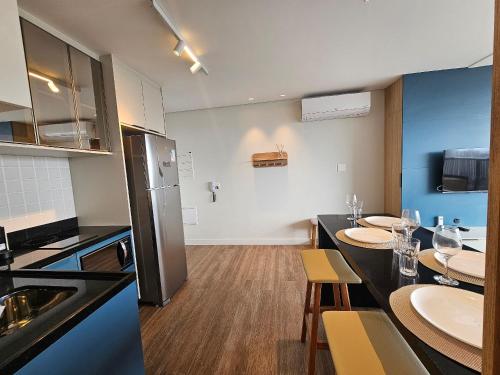 a kitchen with two tables and a kitchen with a counter at Studio Tatuapé - SP in São Paulo
